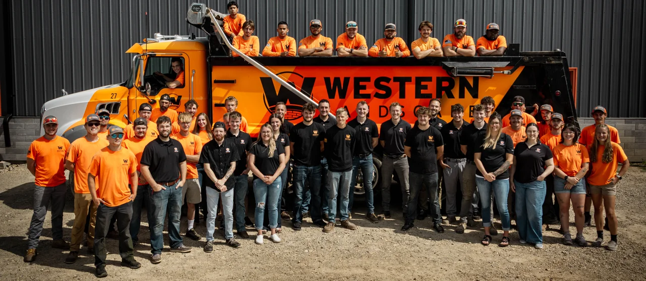 Western Landscape team gathered in front of a company dump truck.